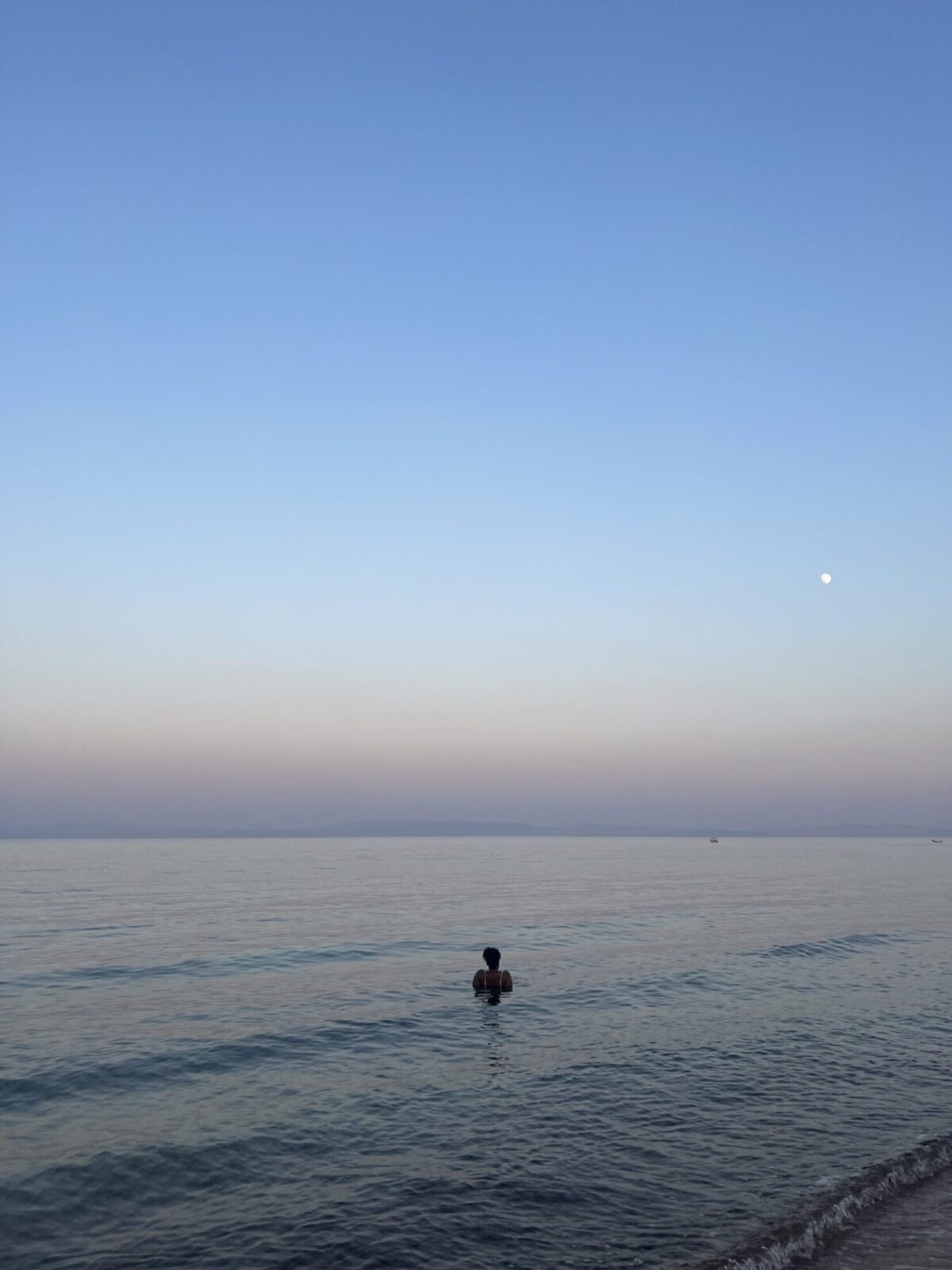 Woman in the water at sunset at a beach in Dahab