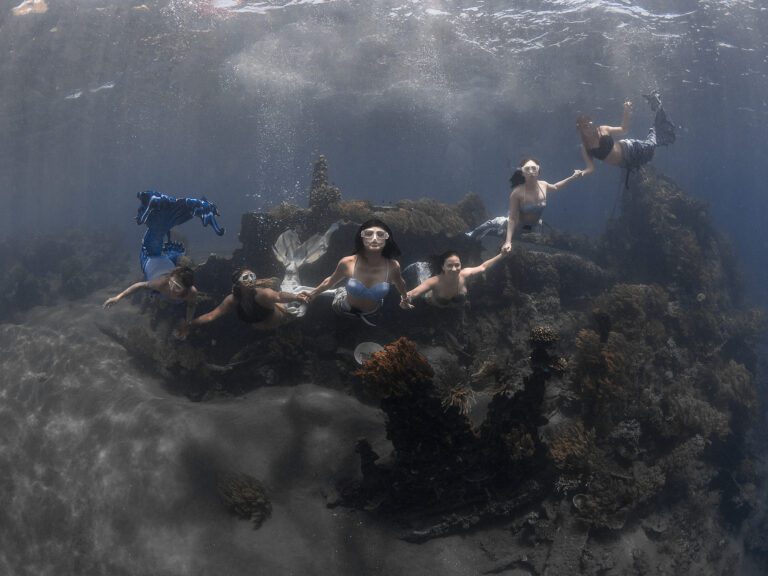 six mermaids holding hands underwater in Amed Bali