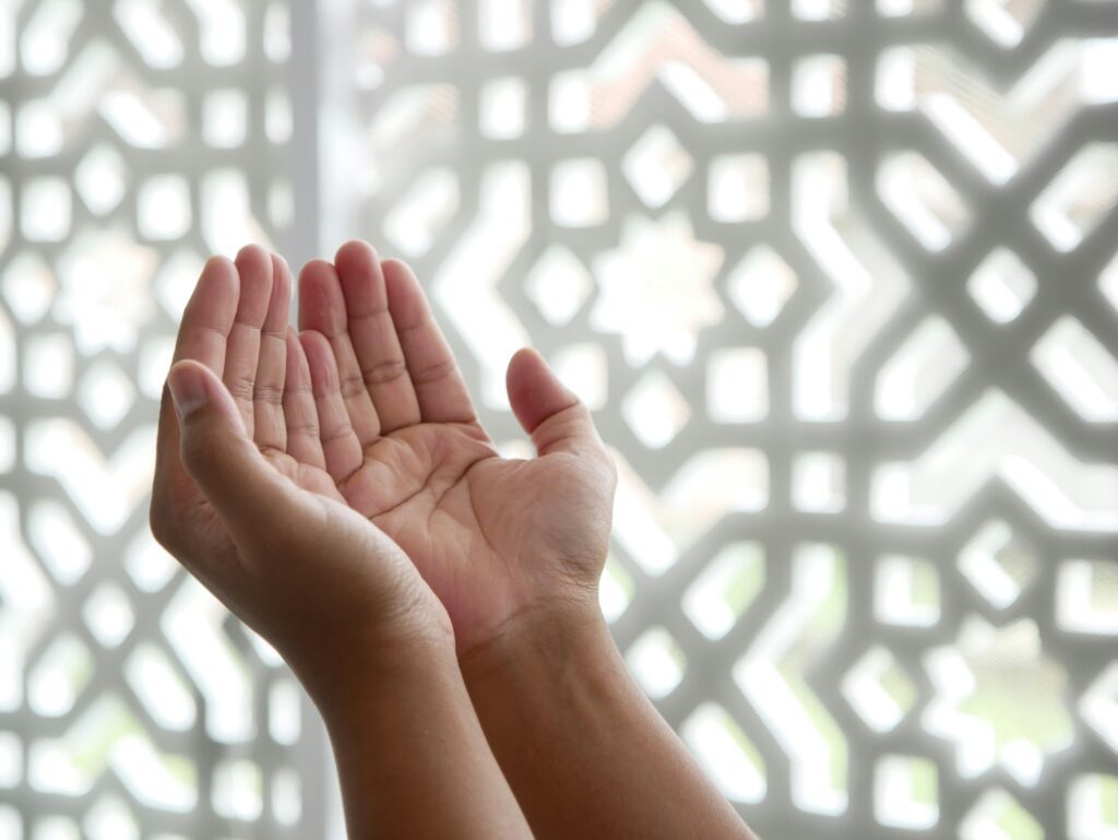 photo of pale hands in making dua or islamic prayer