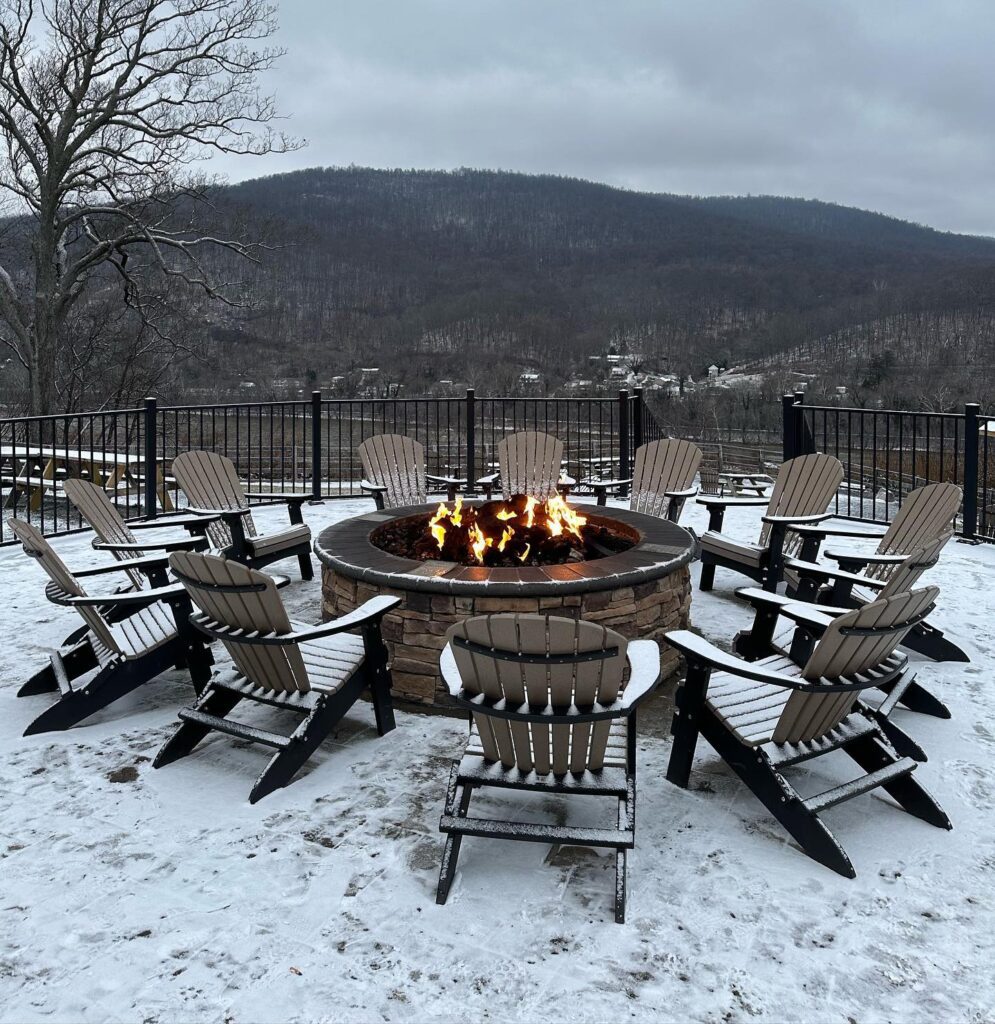 outdoor fireplace surrounded buy lots of chairs on a snowy mountaintop 