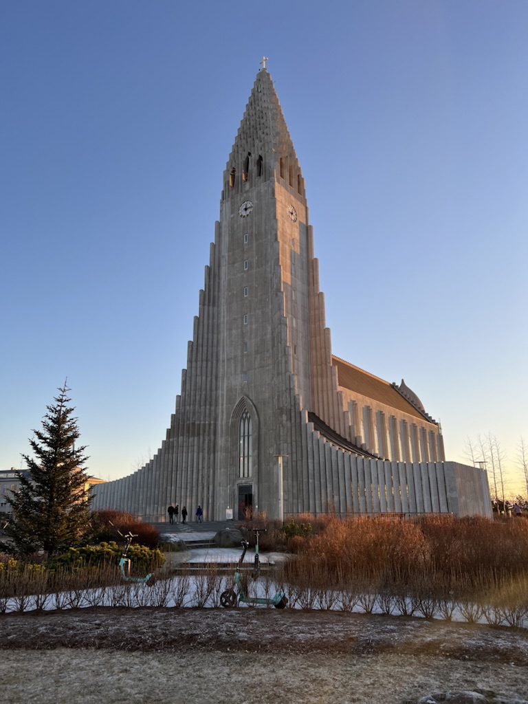 The Hallgrimskirkja church at dusk which has a curved spire and side wings