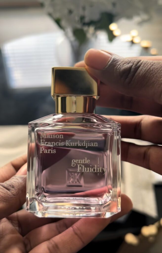 black woman's hands holding a bottle of Gentle Fluidity by Maison Francis Kurkdjian