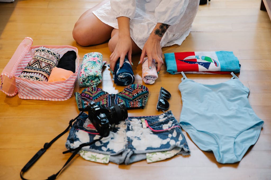 A Person Sitting on a Wooden Floor while Preparing Travel Essentials