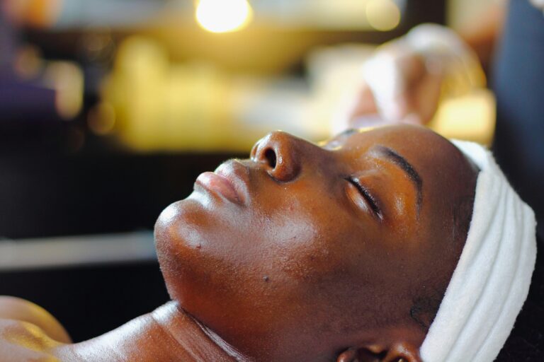 Black woman's face while at the spa. Woman is laying down with her eyes closed.