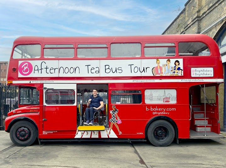 bright red double decker bus with a sign that reads " Afternoon Tea Bus Tour" 