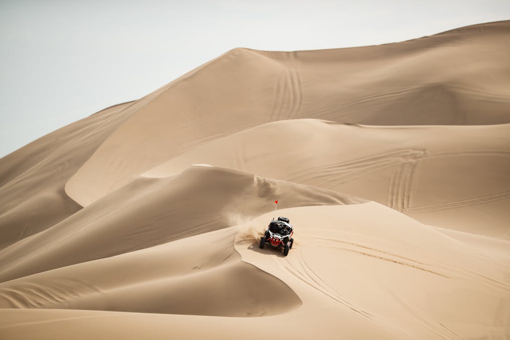 a 4x4 riding in the desert sand dunes