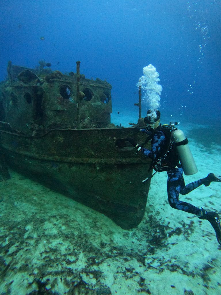 A Scuba Diver Near a Sunken Boat Underwater