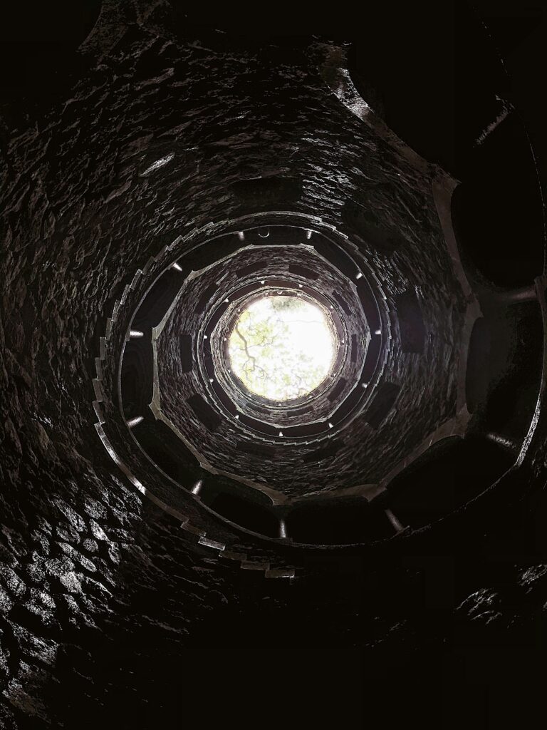 The Initiation Well at Quinta da Regaleira shows an eerie spiraling staircase that lets a lot of light in at the top